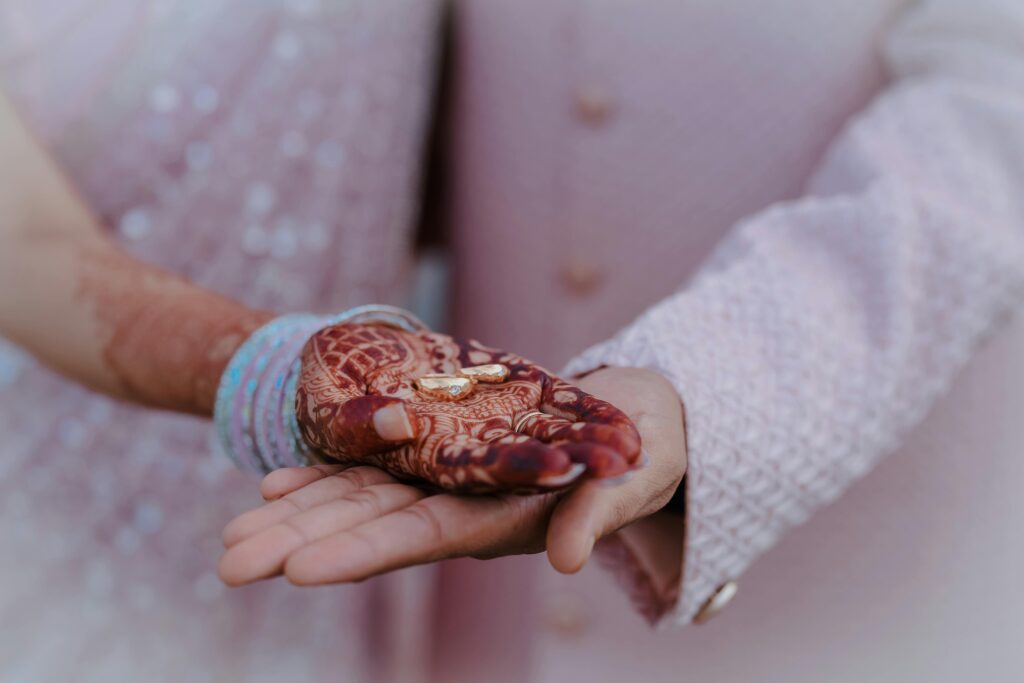Beautiful capture of an Indian engagement ceremony highlighting henna and wedding rings.
